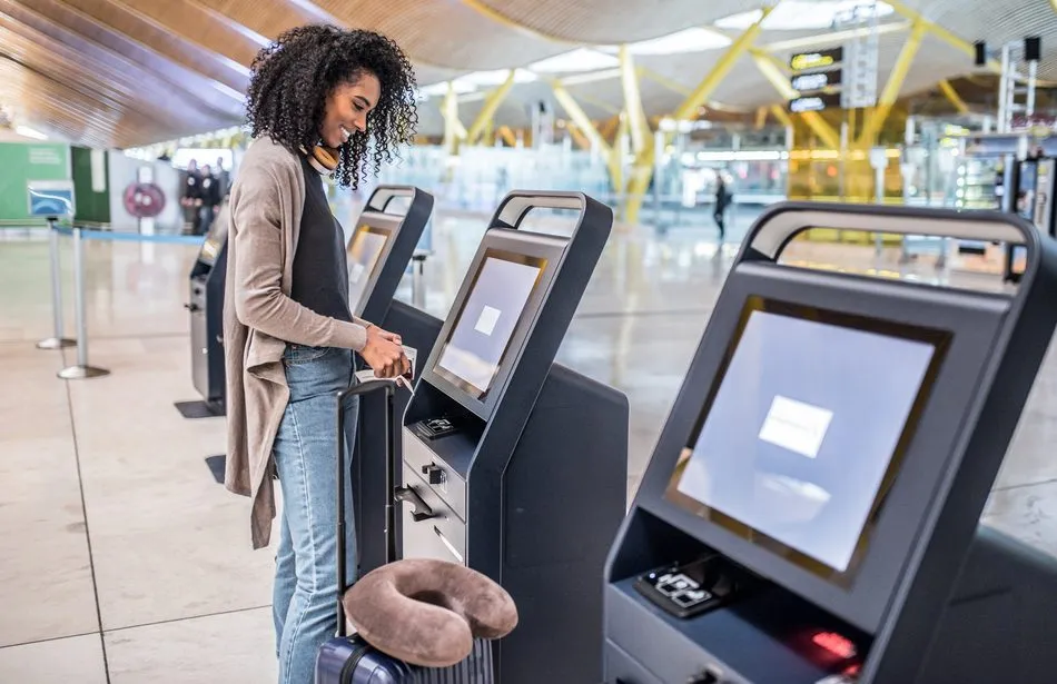 Woman using a kiosk machine at an airport.